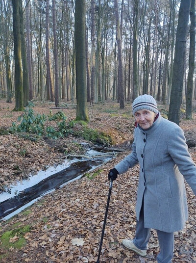 Lieve op wandel in het bos met haar wandelstok