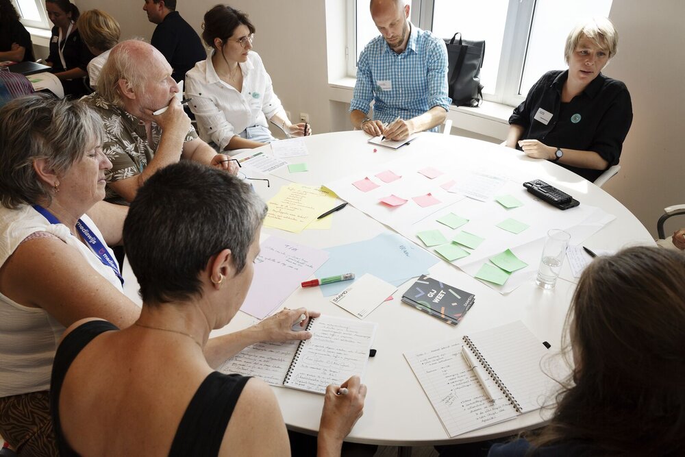 Brainstorm met een groep mensen rond een tafel