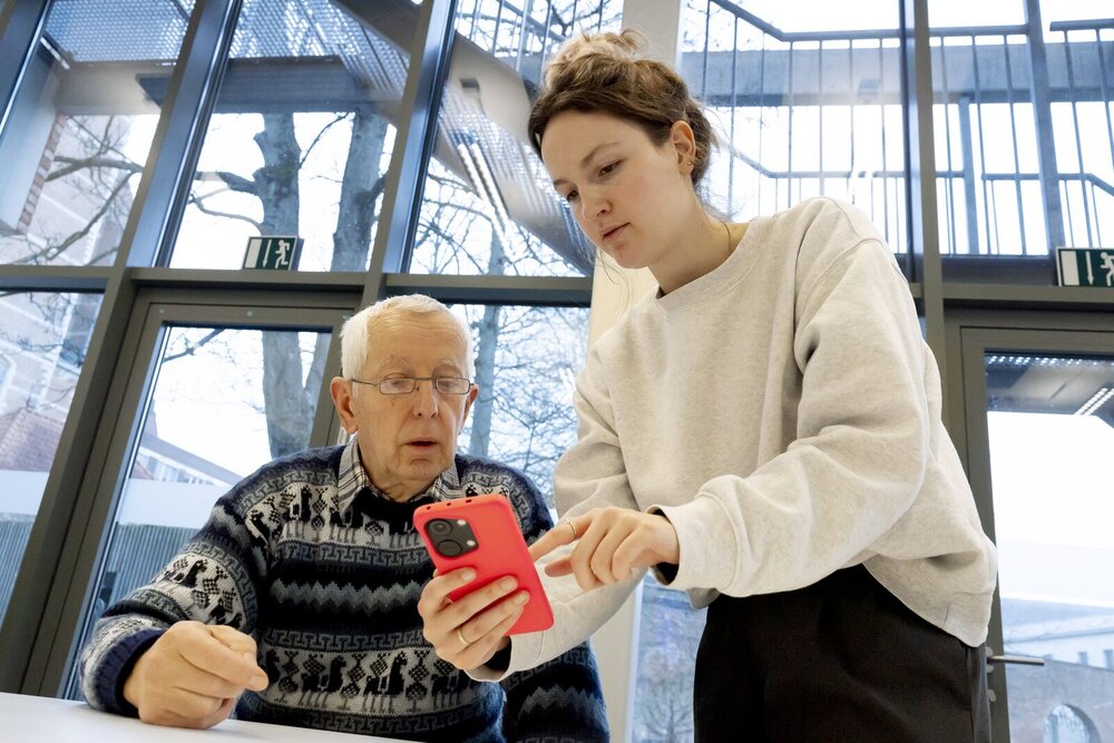 Dame legt heer uit hoe een app te gebruiken op een mobieltje