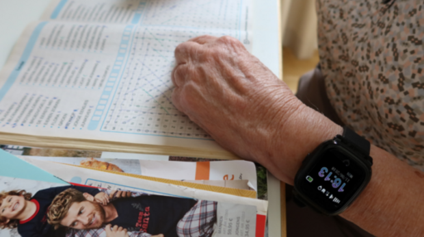 Decoratieve afbeelding: oudere persoon met horlogo leest