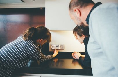 drie mensen krijgen uitleg over werking thermostaat