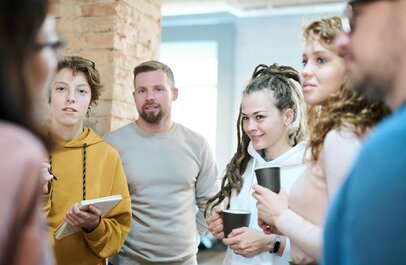 5 mensen die luisteren naar iemand die iets vertelt