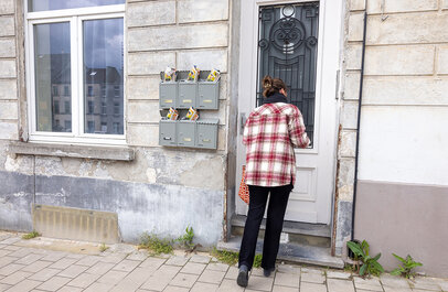 Vrouw opent de deur van een woning