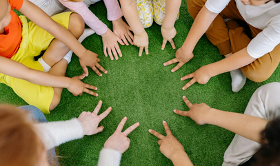 Kinderen met hun handen in een kring.