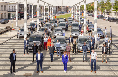 20-tal geparkeerde deelwagens met 30-tal mensen daartussen