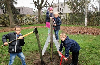Kinderen slaan met een voorhamer palen in de grond. 