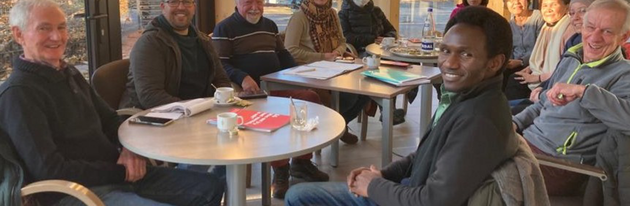 Mensen rond een tafel om Nederlands te leren