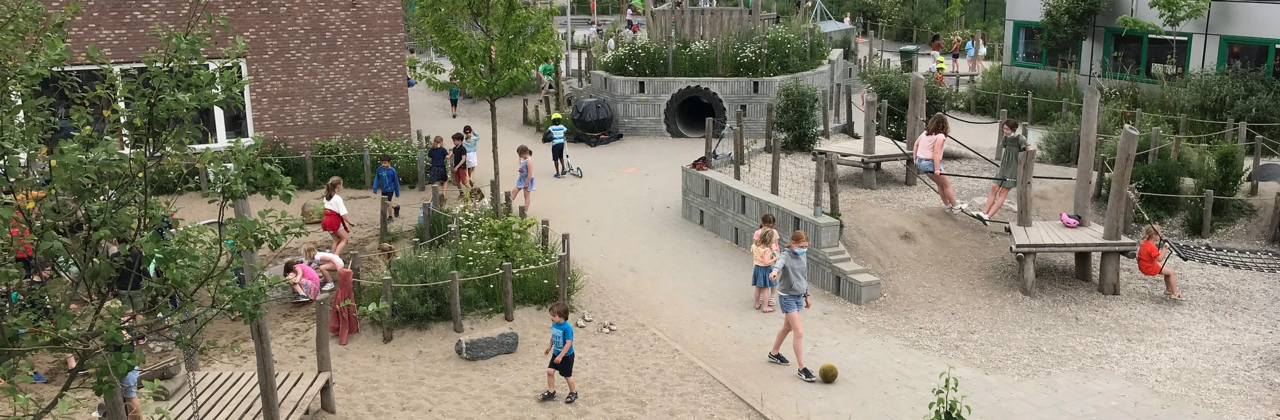 foto van groene speelplaats met spelende kinderen