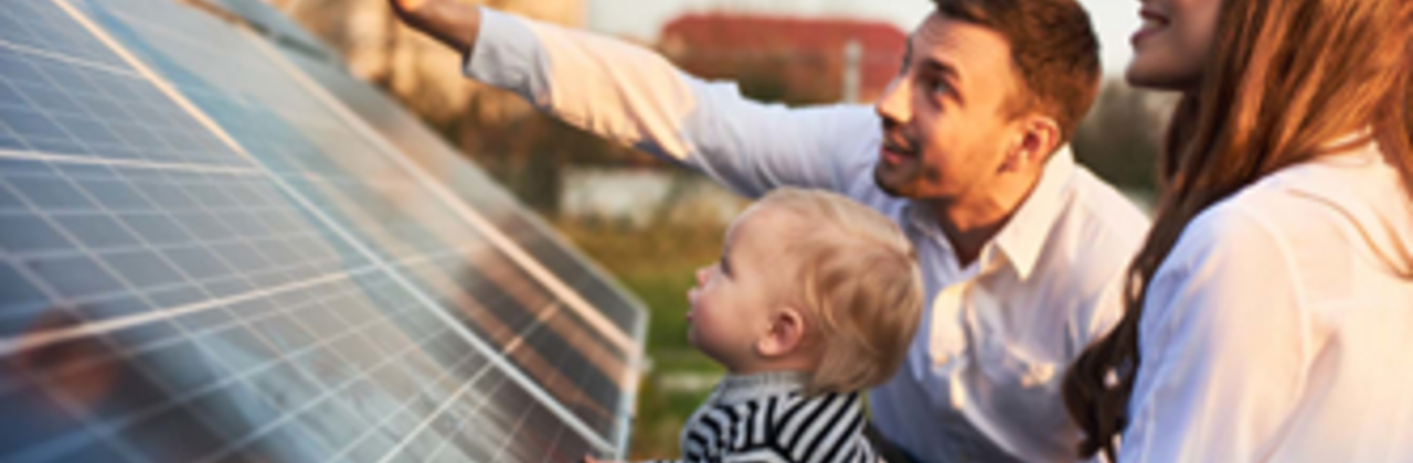 jong gezin naast zonnepanelen