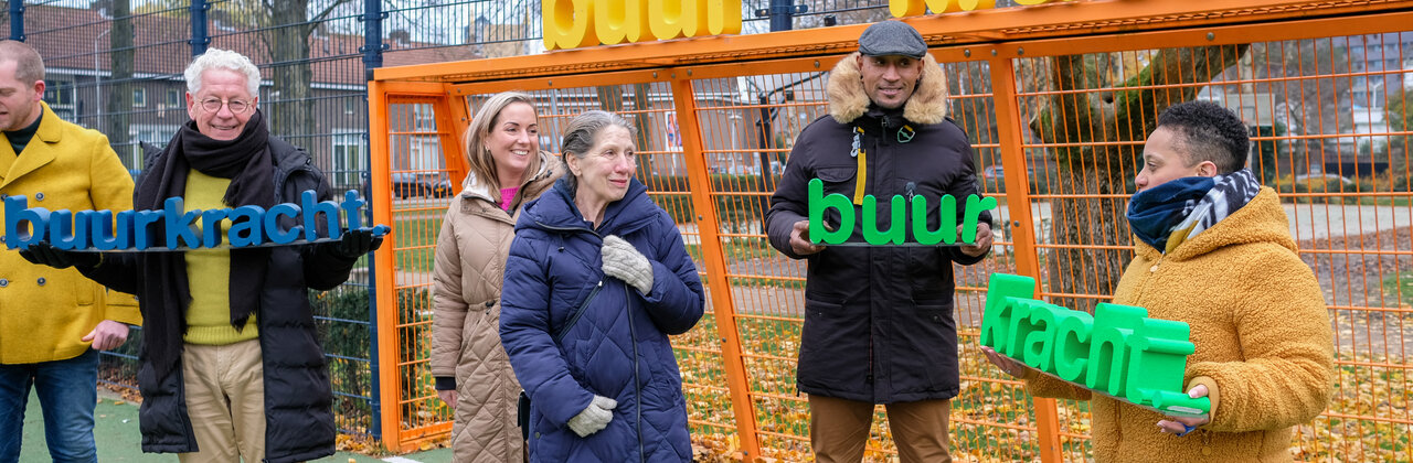 een groepje buren die de letters buurkracht vasthouden