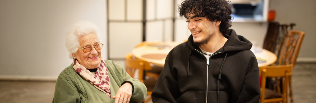 Oudere vrouw aan het lachen samen met jonge man.