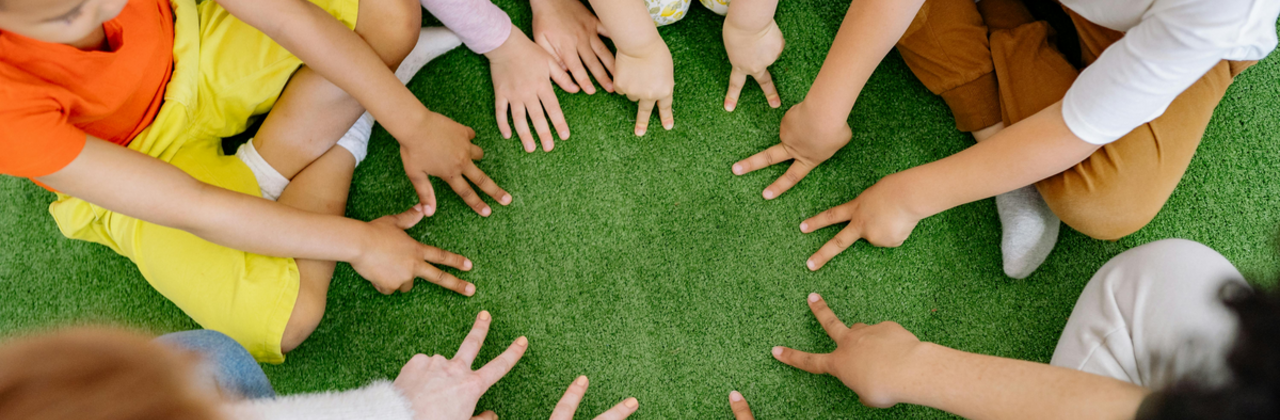 Kinderen met hun handen in een kring.