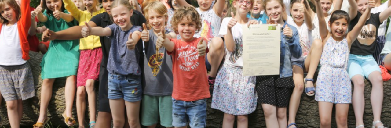 20-tal enthousiaste kinderen met de duim omhoog