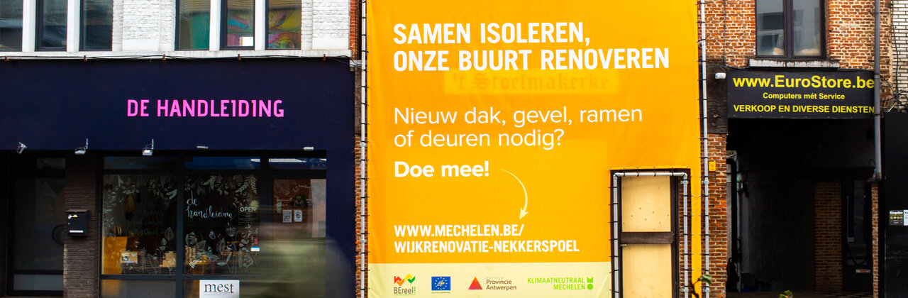 foto van rijwoningen met grote affiche in de vorm van een van de woningen