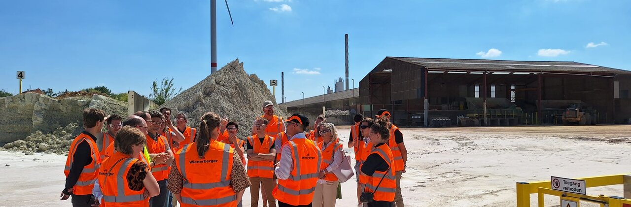 foto van groepje mensen op bezoek op de site met windturbine