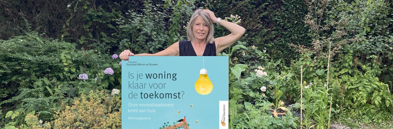 vrouw in tuin met affiche 'is je woning klaar voor de toekomst'