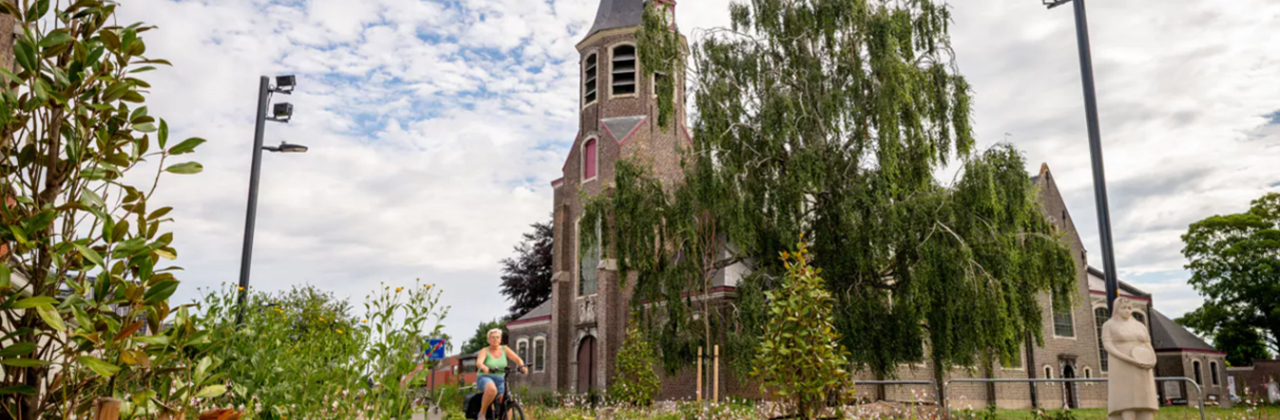 Kruispunt met groen en een kerk.