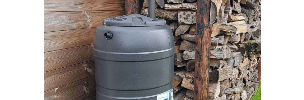 regenwaterton naast gestapeld hout
