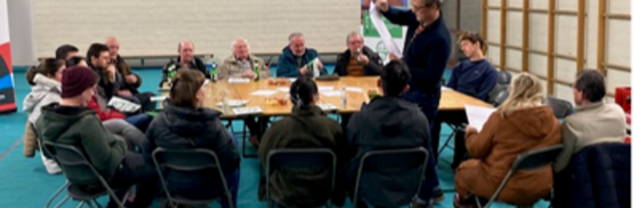 Afbeelding van een tafel waar mensen rond zitten te debatteren