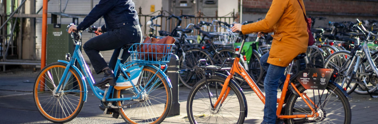 foto van 2 mensen op verschillende deelfietsen