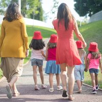 3 kinderen met 2 begeleidsters zijn aan het wandelen