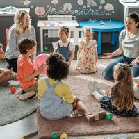Kindjes met begeleidster in een kring
