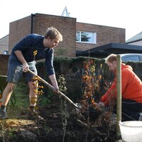Twee mannen bewerken een stuk grond in Balen. 
