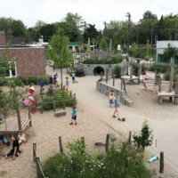 foto van groene speelplaats met spelende kinderen
