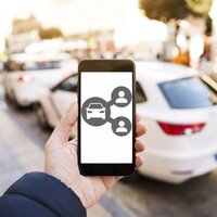 hand houd GSM vast met geparkeerde wagen in achtergrond