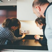 drie mensen krijgen uitleg over werking thermostaat