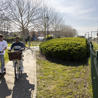 Fietser en step die door het park rijden