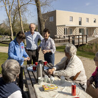 Mensen die aan een bank zitten te eten in het park