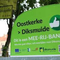 Groen bord waarop staat 'dit is een mee-rij bank'