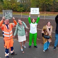 Gelukkige medewerkers van lokaal bestuur Boom steken affiches in de lucht