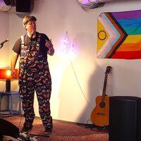 Persoon naast de LGBTI+ vlag