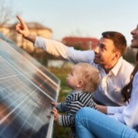 jong gezin naast zonnepanelen