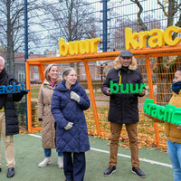 een groepje buren die de letters buurkracht vasthouden