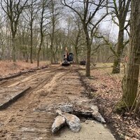 werkzaamheden op een onverharde weg in bos