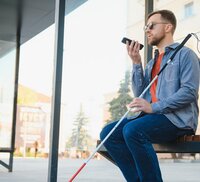 Blinde persoon aan bushalte