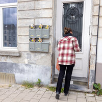 Vrouw opent de deur van een woning