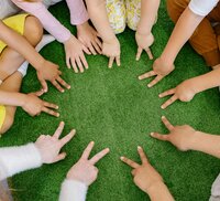 Kinderen met hun handen in een kring.