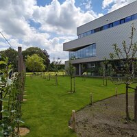 Pluktuin met fruitbomen en daarnaast een gebouw