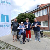 enkele bewoners met een flyer voor een woning met zonnapanelen