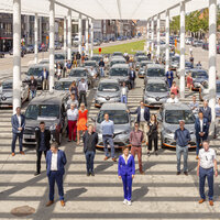20-tal geparkeerde deelwagens met 30-tal mensen daartussen
