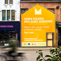 foto van rijwoningen met grote affiche in de vorm van een van de woningen