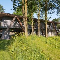gebouw in de achtergrond, bloemen en bomen in de voorgrond