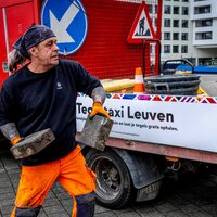 Man werpt straattegels in een laadbak van een vrachtwagen. 