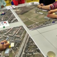 foto van een workshop met luchtfoto's bij opmaak van het plan