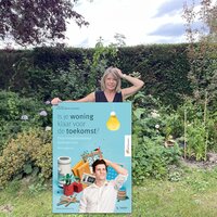 vrouw in tuin met affiche 'is je woning klaar voor de toekomst'