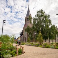 Kruispunt met groen en een kerk. 